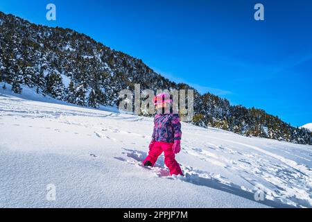 Fille debout dans la neige profonde avec les montagnes et la forêt dans un fond, Andorre Banque D'Images