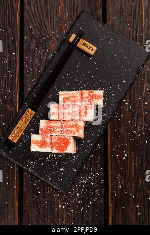 Sushis maki sucrées asiatiques avec vue sur le dessus - rouler avec des fruits et du fromage à la crème avec des flocons de noix de coco et de la garniture Banque D'Images