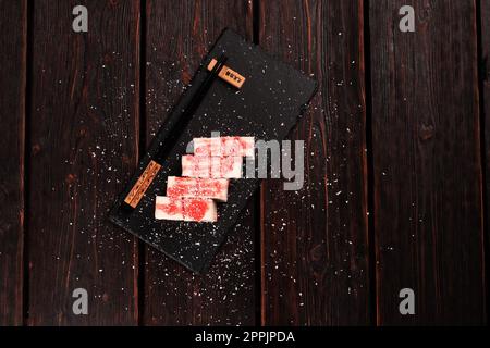 Sushi maki au dessert asiatique - rouler avec des fruits et du fromage à la crème avec des flocons de noix de coco et un espace de copie de garniture et un espace vide pour le texte Banque D'Images