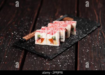 Sushis maki sucrées asiatiques - roulez avec des fruits et du fromage à la crème avec des flocons de noix de coco et de la garniture Banque D'Images