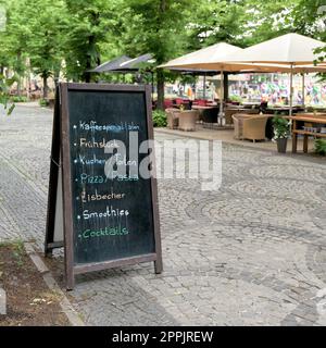 Tableau noir avec les offres actuelles en face d'un café dans le centre de Berlin Banque D'Images