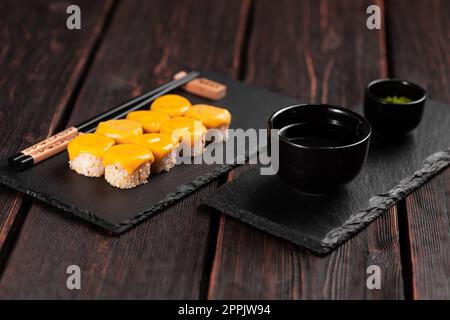 Un petit pain de sushi accompagné de fromage et de baguettes est un concept de cuisine asiatique japonaise Banque D'Images