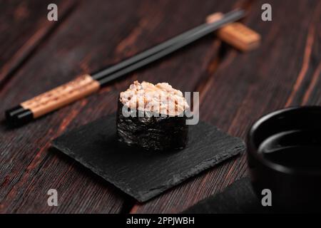 Gunkan Maki Sushi de poisson saumon, pétoncle, perche, anguille, crevettes et caviar sur fond de table en bois. Menu sushi. Ensemble de sushis japonais gunkans Banque D'Images