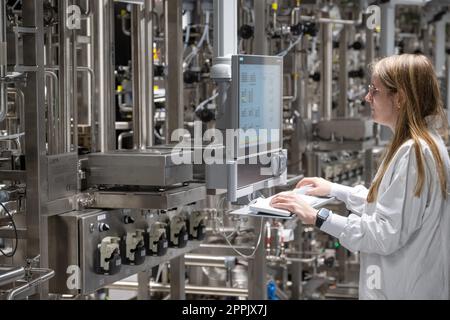 24 avril 2023, Baden-Württemberg, Biberach an der Riß : Julia Gueter occupe une salle avec des fermenteurs cellulaires dans le centre de développement interdisciplinaire de la biotechnologie de la société pharmaceutique Boehringer Ingelheim Pharma GmbH & Co KG dans une pièce avec fermenteurs de cellules. À l'avenir, des médicaments basés sur la technologie cellulaire seront développés ici. Huit étages et un laboratoire de la taille d'environ cinq terrains de football: La société pharmaceutique Boehringer Ingelheim a ouvert lundi un nouveau centre de développement de la biotechnologie à Biberach. Là, les scientifiques développeront de nouveaux médicaments et thérapies avec anti Banque D'Images