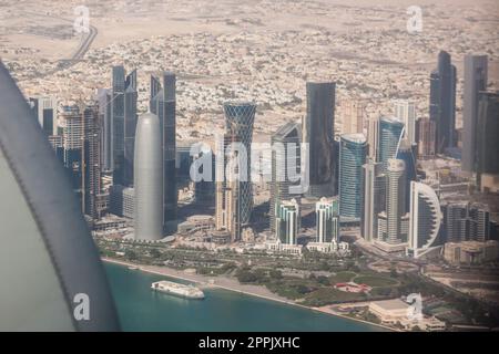 Vue aérienne de Doha à travers la fenêtre d'avion, capitale du Qatar dans le golfe Persique Banque D'Images