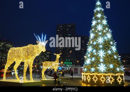 Moscou, Russie, janvier 17 2023 arbre de Noël de rue avec des flocons de neige et des boules festives. Métro Yugo-Zapadnaya. Décorations de Noël devant le centre commercial. Étoiles argentées, flocons de neige et cerfs dorés Banque D'Images