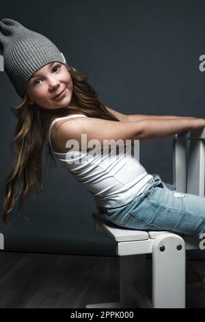 Petite fille modèle professionnellement posant dans le studio en jeans et un T-shirt blanc. Tests de modèles Banque D'Images