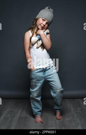 Petite fille modèle professionnellement posant dans le studio en jeans et un T-shirt blanc. Tests de modèles Banque D'Images