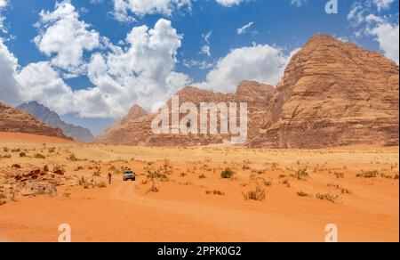 Sable orange et falaises du désert de Wadi Rum avec voiture touristique en arrière-plan, Jordanie Banque D'Images