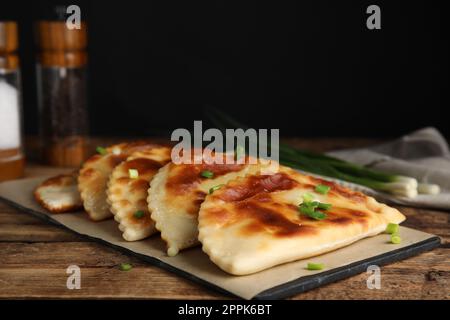 Planche avec un délicieux chebureki frit sur une table en bois Banque D'Images