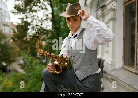 Portrait d'un jeune musicien tenant un instrument de musique saxophone Banque D'Images