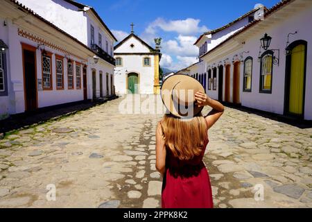 Visite de l'architecture coloniale en Amérique latine. Vue arrière de la jeune touriste dans la ville historique de Paraty, Brésil, Amérique du Sud. Banque D'Images