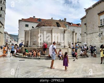 Grande fontaine Onofrio, Velika Onofrijeva chesma, Dubrovnik, Croatie. Approvisionnement en eau établi pendant la période Quattrocento. De nombreux touristes heureux multinationaux marchent sur le Stradun 14 août 2022 Banque D'Images