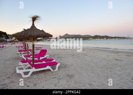 Alcudia, Mallorca - 4 mai 2019: Chaises longues avec parasol sur la plage de sable d'Alcudia, Majorque Banque D'Images