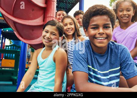 Devinez où vous pouvez vous en sortir cet été. un groupe de jeunes amis qui se traînaient ensemble sur un terrain de jeu. Banque D'Images