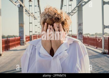 Gros plan femme à poil court couvrant le visage avec les mains portrait image Banque D'Images