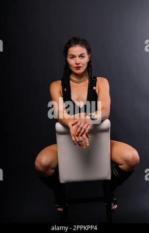 Femme sportive avec de grands muscles abdominaux dans des vêtements de sport noirs. Un corps de sport de près. Banque D'Images