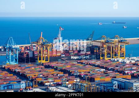 BARCELONE, ESPAGNE - 31 janvier 2023 : le port commercial de Barcelone avec un navire à conteneurs, des grues et des réservoirs de stockage Banque D'Images