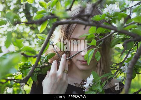 Gros plan femme regardant à travers la pomme branches portrait image Banque D'Images