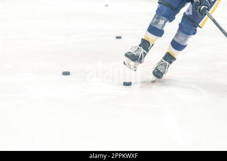 palet de hockey sur la glace du stade d'hiver. patins d'un joueur de hockey pendant l'entraînement Banque D'Images