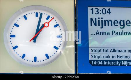 DEN HELDER, PAYS-BAS - 25 AOÛT 2013 : horloge et panneau annonçant le départ d'un train sur un quai à la gare de Den Helder, province de Hollande du Nord, pays-Bas Banque D'Images