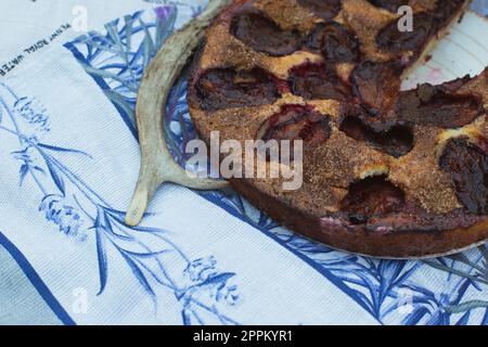 Gros plan sur une tarte aux prunes maison sur une couverture à motif floral Banque D'Images