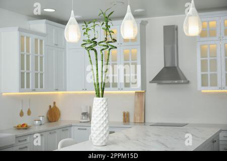 Vase avec tiges en bambou vert sur table en marbre dans la cuisine. Design intérieur Banque D'Images