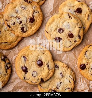 Biscuits aux pépites de chocolat au sel feuilleté sur papier parchemin, biscuits maison fraîchement cuits Banque D'Images