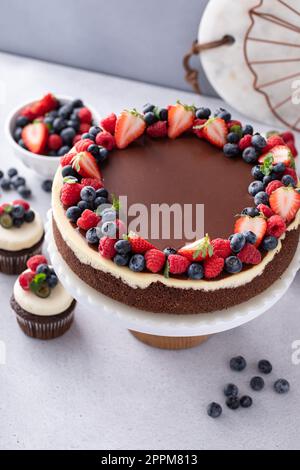 Gâteau au chocolat et à la vanille recouvert de ganache au chocolat noir et de baies d'été Banque D'Images
