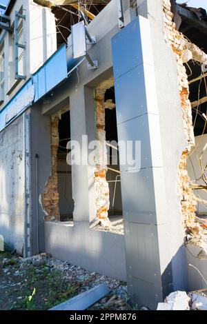 Contexte du processus de démolition du bâtiment. Une pelle hydraulique brise une vieille maison. Banque D'Images