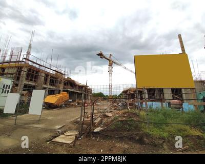 Sremska Mitrovica, Serbie. 10 juin 2020. Construction d'un immeuble d'appartements dans le cadre du programme d'État pour les réfugiés, la police et le personnel militaire. Panneaux d'affichage, matériaux de construction et grue Banque D'Images