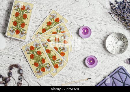 Cartes de tarot étalées face vers le haut sur la surface tricotée blanche avec boule de cristal, lavande, bougies. Minsk, Biélorussie, 11.10.2021 Banque D'Images