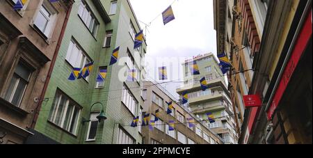 Sarajevo, Bosnie-Herzégovine, 8 mars 2020. Rues décorées avec des drapeaux nationaux de Sarajevo. Bâtiments anciens dans le centre-ville. Zone touristique avec commerces, expositions, cafés et restaurants Banque D'Images