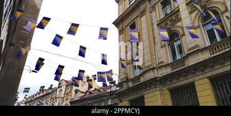 Sarajevo, Bosnie-Herzégovine, 8 mars 2020. Rues de Sarajevo avec drapeaux. Centre historique et touristique de la ville. Vue de bas en haut. Façades de maisons anciennes, décorations festives. Banque D'Images