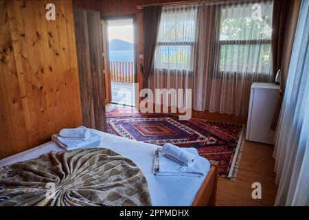 Une chambre accueillante et confortable avec un grand lit et deux fenêtres permettant à la lumière naturelle de remplir l'espace Banque D'Images