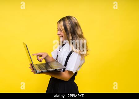 Petite fille excitée de 12-13 ans isolé sur fond jaune. Concept de mode de vie de l'enfance. Banque D'Images