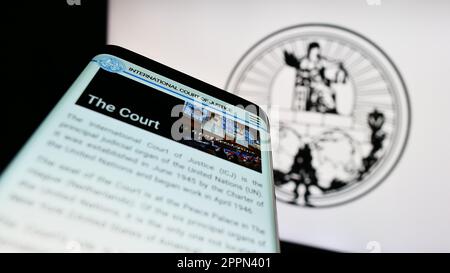 Téléphone mobile avec page web de la Cour internationale de Justice (CIJ) à l'écran devant le logo. Faites la mise au point dans le coin supérieur gauche de l'écran du téléphone. Banque D'Images