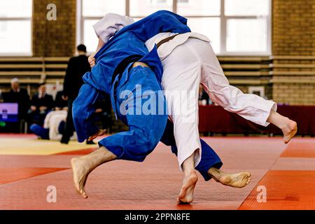 deux athlètes judoka qui se battent en tatami rouge, championnat de combat judo Banque D'Images