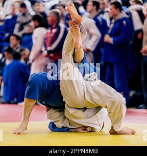 deux judoistes mentent sur le tatami dans la compétition de judo de combat Banque D'Images