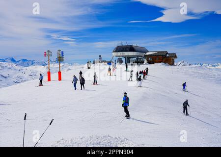 Skieurs quittant la station de télésiège du Roc 2 au sommet des pistes de la station de ski des Ménuires dans les Alpes françaises en hiver Banque D'Images