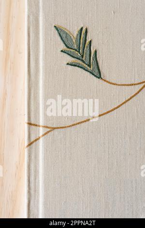 bord de livre en tissu à broderie machine avec motifs floraux décoratifs sur bois uni Banque D'Images
