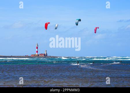 Kitesurfers pratiquant sur la côte atlantique, devant le phare d'El Toston, sur la côte nord de Fuerteventura, dans les îles Canaries, en Espagne Banque D'Images