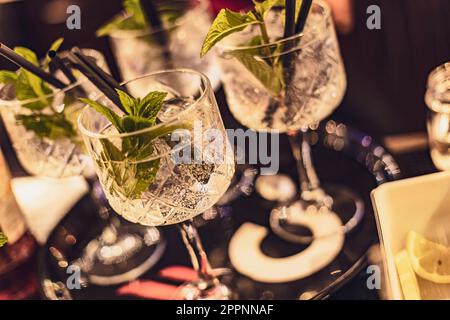 Boissons rafraîchissantes et élégantes dans des verres en cristal sur fond noir. Idéal pour les styles de vie luxueux ou les concepts de bar. Banque D'Images