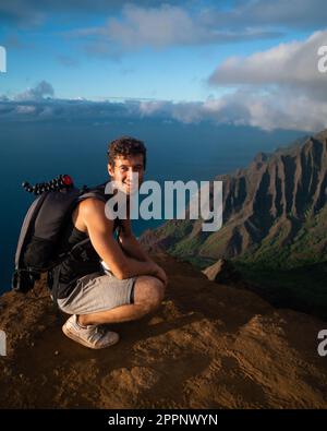 Homme en randonnée jusqu'au sommet du parc national de la côte de Na Pali à Kauai, Hawaï au coucher du soleil. Photo de haute qualité. Banque D'Images