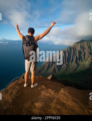 Homme en randonnée jusqu'au sommet du parc national de la côte de Na Pali à Kauai, Hawaï au coucher du soleil. Photo de haute qualité. Banque D'Images