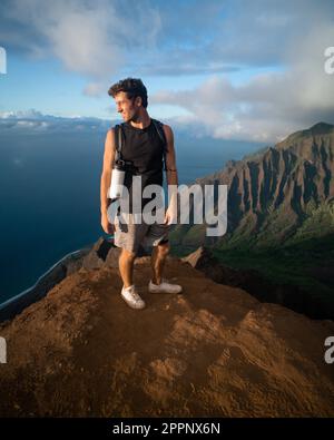 Homme en randonnée jusqu'au sommet du parc national de la côte de Na Pali à Kauai, Hawaï au coucher du soleil. Photo de haute qualité. Banque D'Images