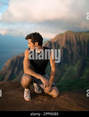 Homme en randonnée jusqu'au sommet du parc national de la côte de Na Pali à Kauai, Hawaï au coucher du soleil. Photo de haute qualité. Banque D'Images