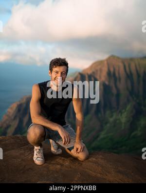 Homme en randonnée jusqu'au sommet du parc national de la côte de Na Pali à Kauai, Hawaï au coucher du soleil. Photo de haute qualité. Banque D'Images