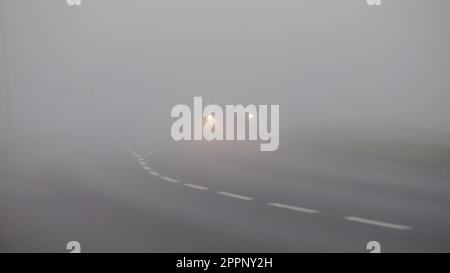 Milton Keynes, Bucks, Royaume-Uni, 8 avril 2023. Voiture roulant dans le brouillard sur une route de campagne anglaise Banque D'Images