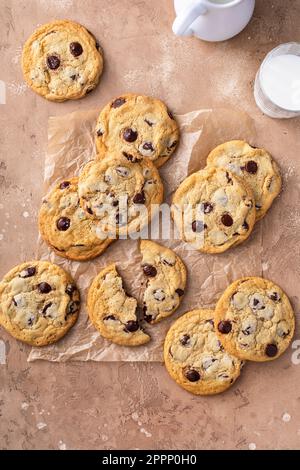 Biscuits aux pépites de chocolat au sel feuilleté sur papier parchemin, biscuits maison fraîchement cuits Banque D'Images